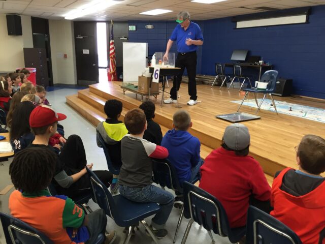 Professor giving a science demonstration to children