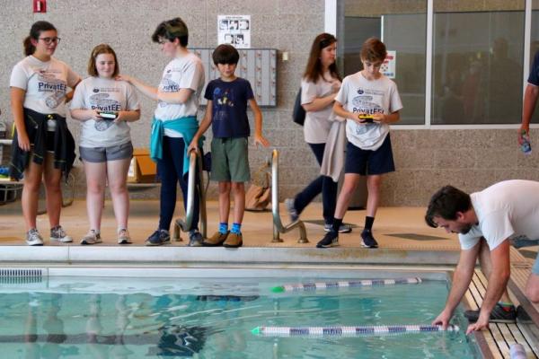 Students testing robots in a pool