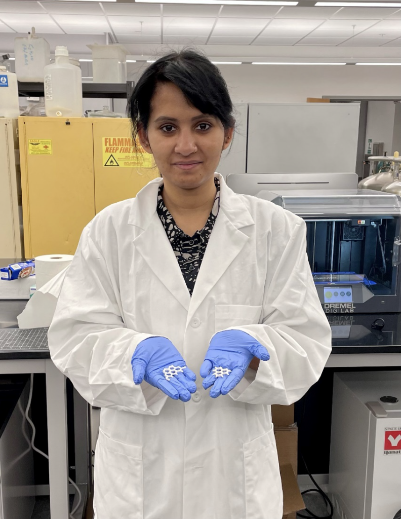 Researcher holding 3D printed structures in her hands.